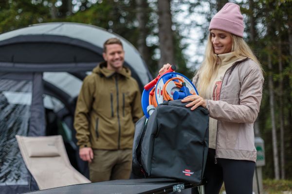 Eine Frau packt die Camping Kabeltrommel aus der Aufbewahrungstasche